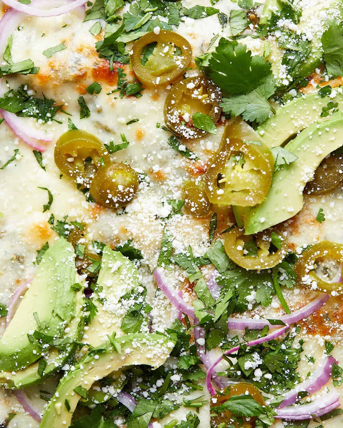 Up close image of chicken enchiladas with garnish.