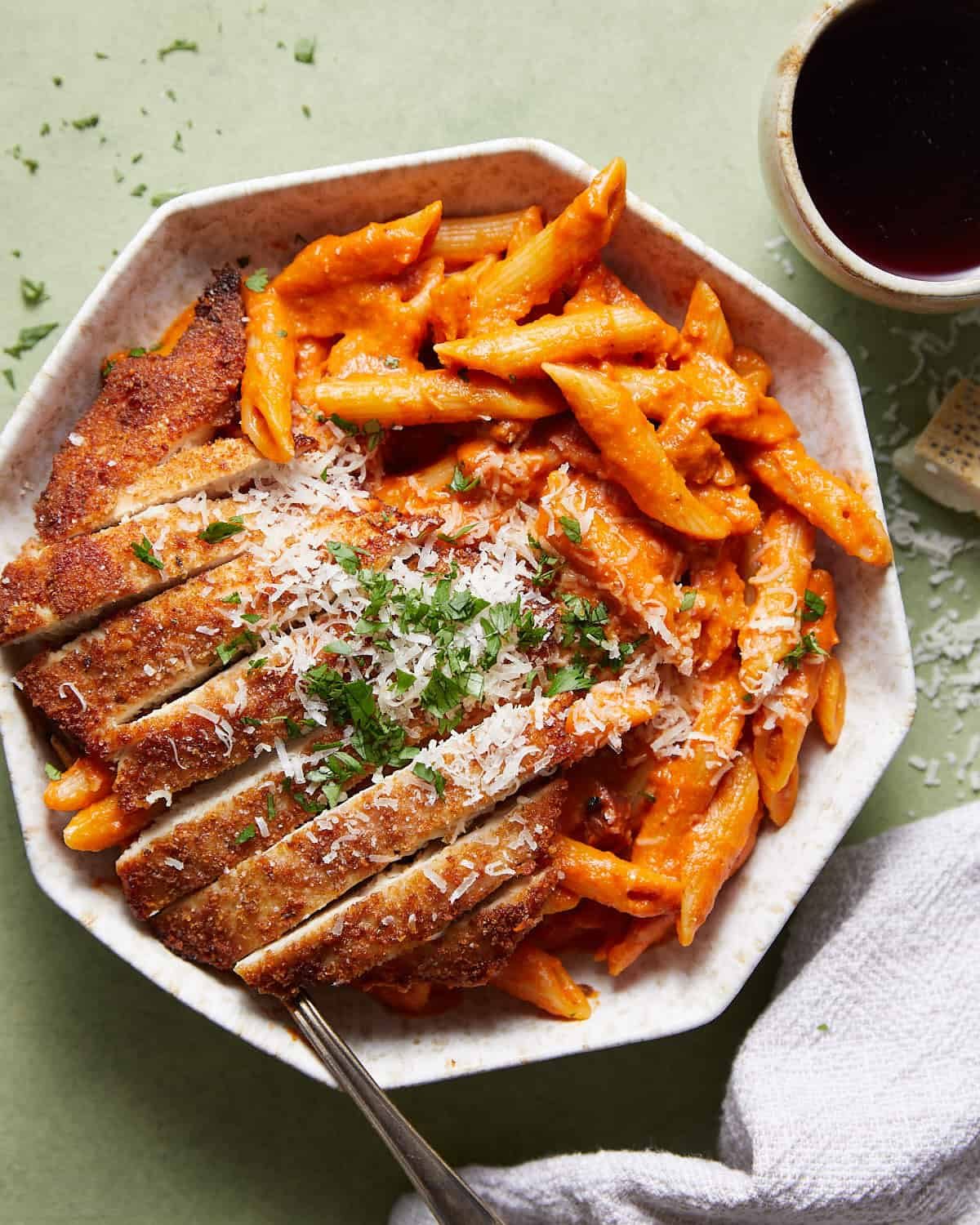 Overhead image of penne alla vodka with chicken in white dish with garnish.