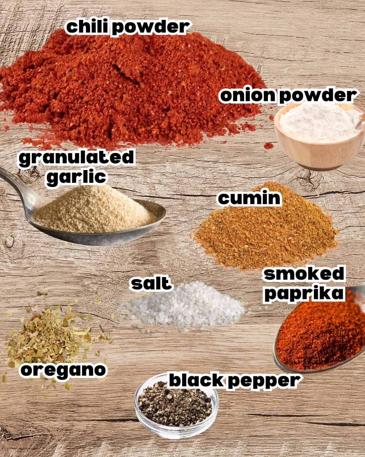 Overhead image of spices used for a homemade chili seasoning recipe, including chili powder, cumin, paprika, garlic powder, and oregano.