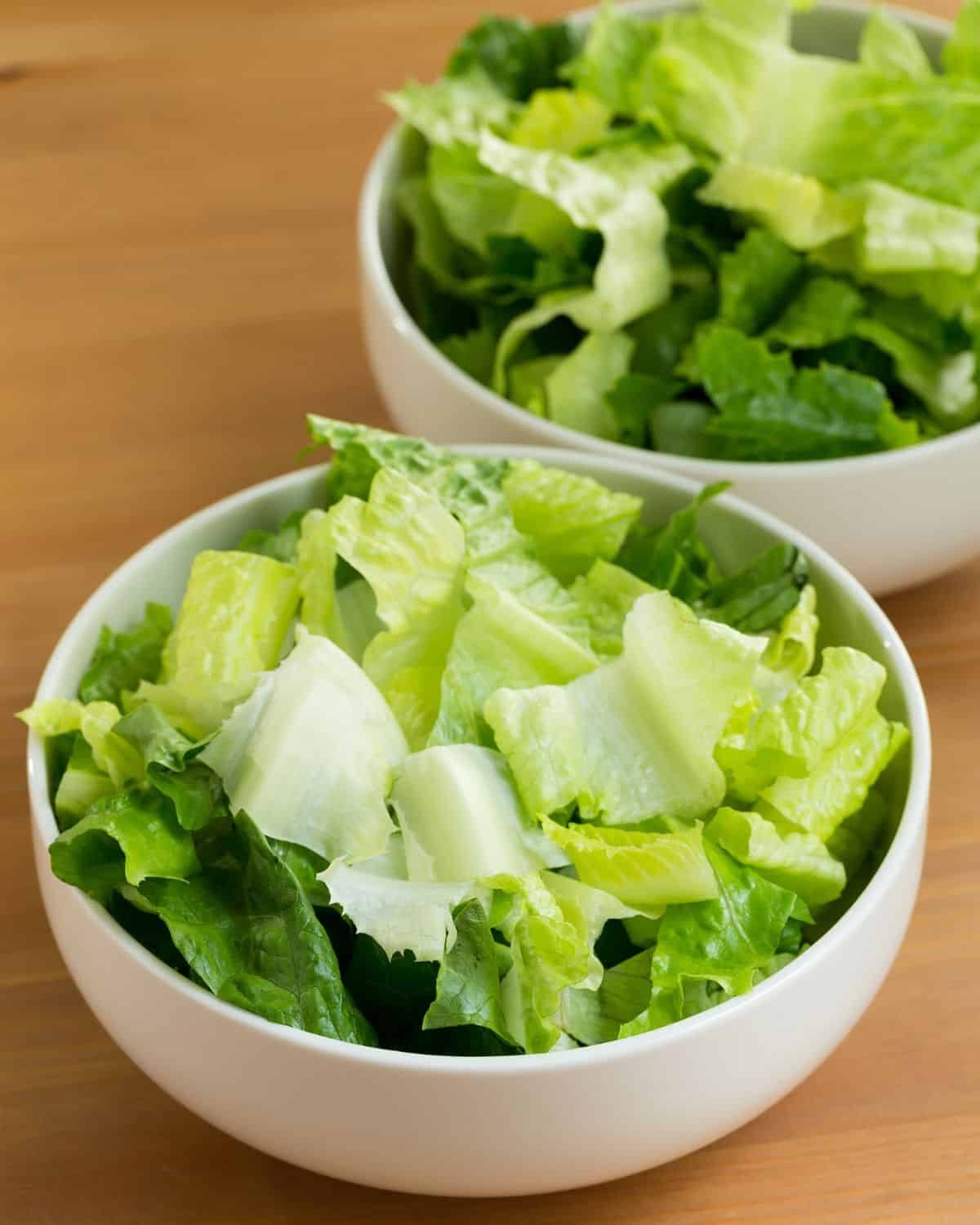 Overhead chopped romaine lettuce in white bowl.