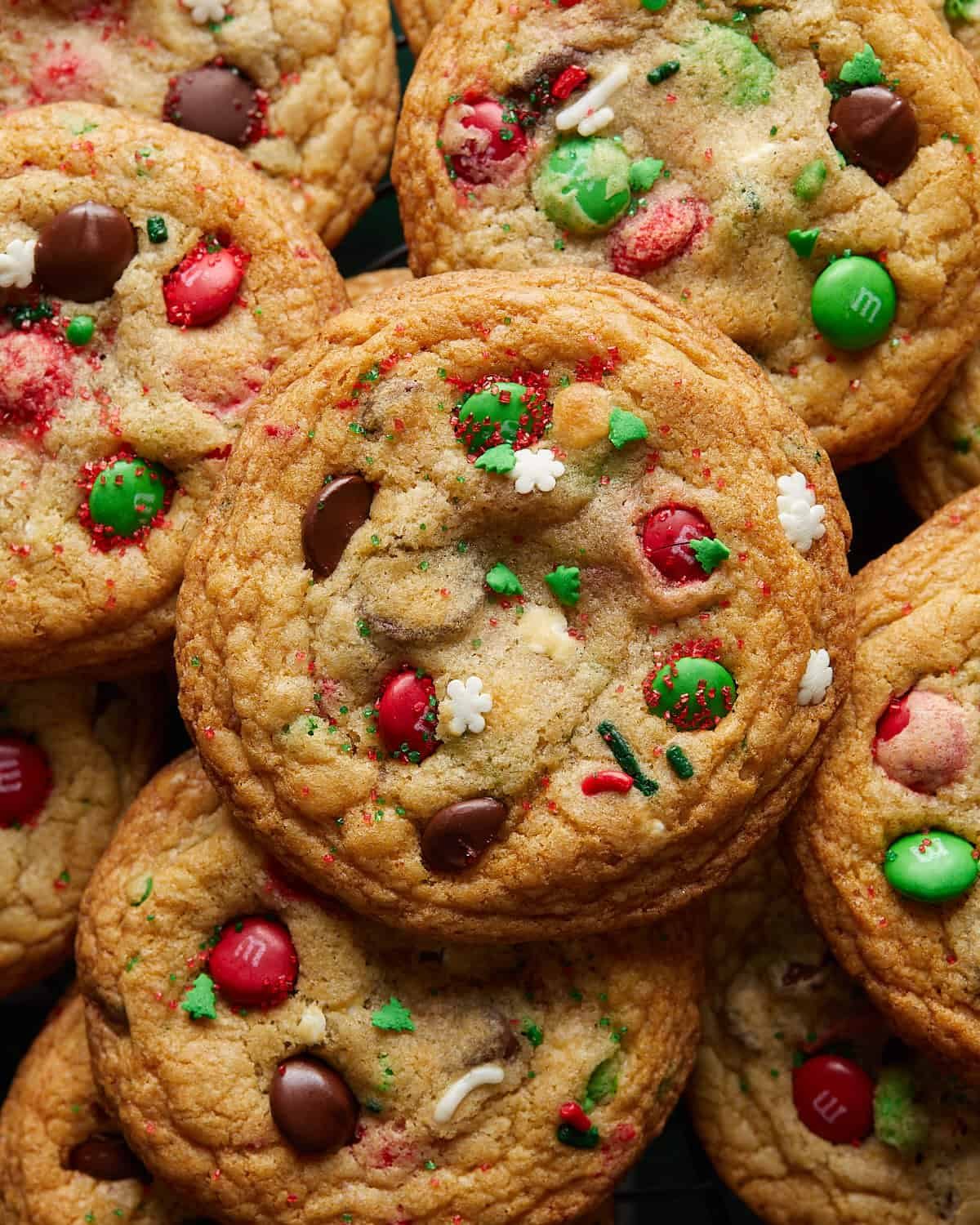 Up close image of soft and chewy Christmas chocolate chip cookies with melted chocolate chips and festive holiday sprinkles, highlighting the rich texture and gooey centers.