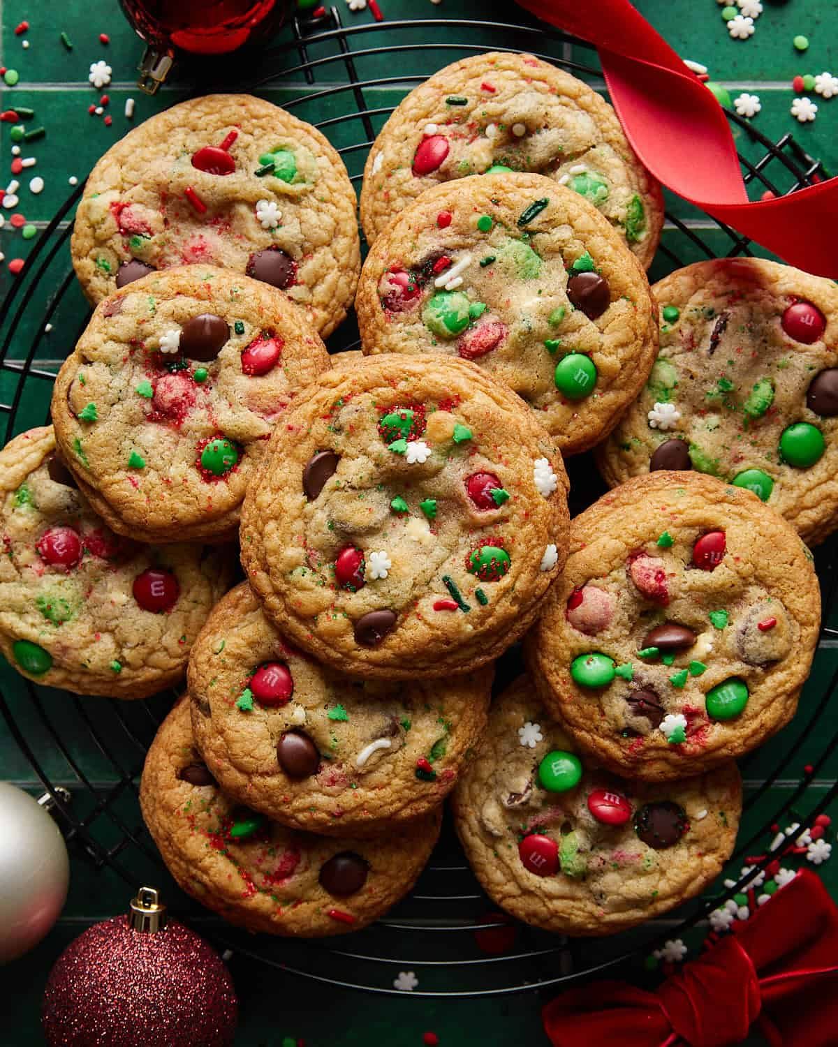Overhead image of homemade Christmas chocolate chip cookies stacked on a cooling rack, featuring soft centers, gooey chocolate chips, and festive holiday baking vibes.