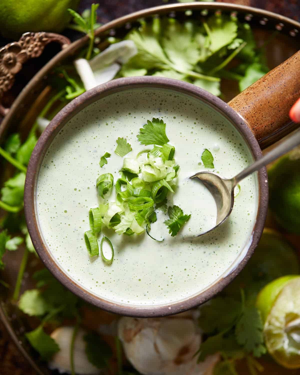 Overhead shot of cilantro garlic sauce in a brown bowl.
