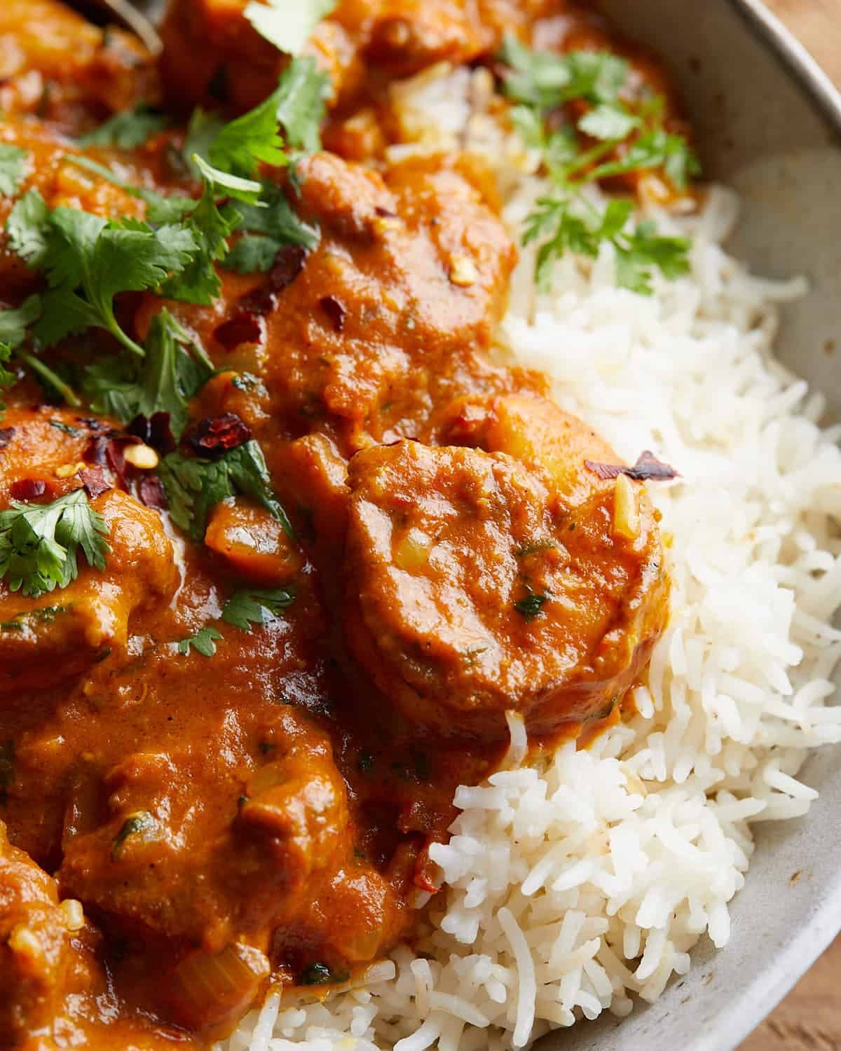 Up close image of coconut curry shrimp with garnish.