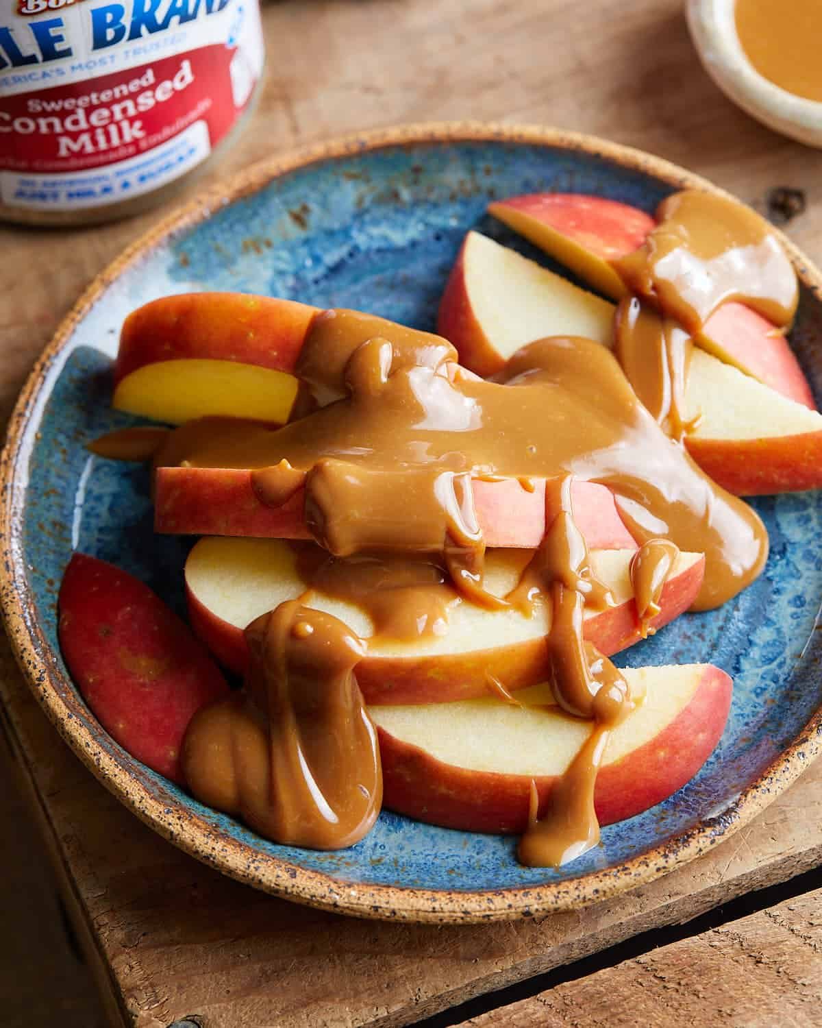Overhead image of caramel on sliced red apples.