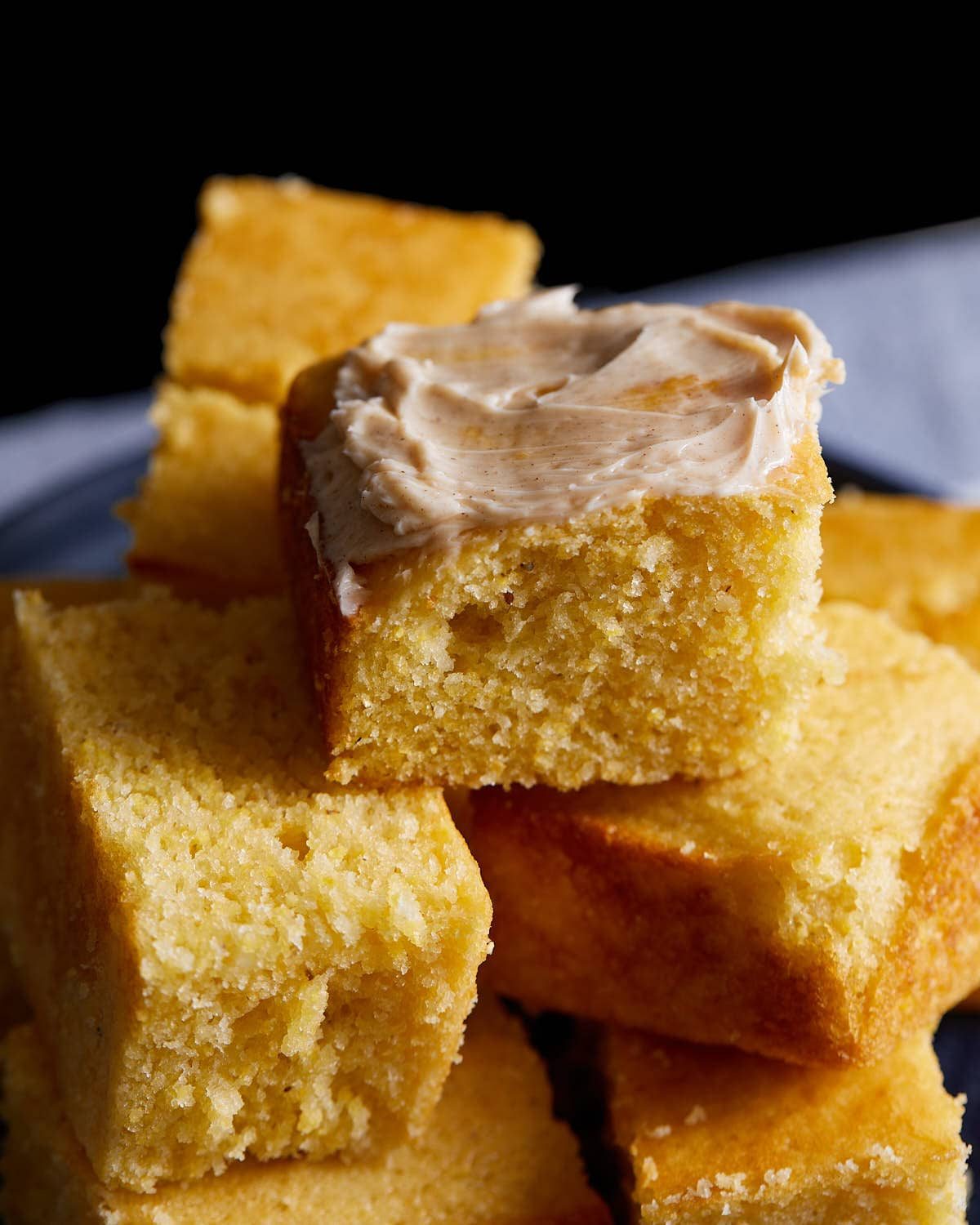 Slice of cornbread with honey cinnamon butter on top.