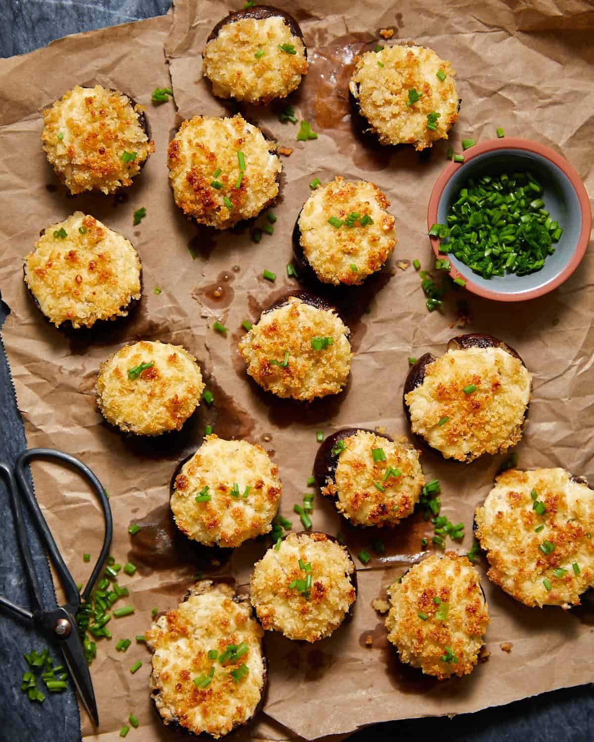 Overhead image of cream cheese stuffed mushrooms with garnish.