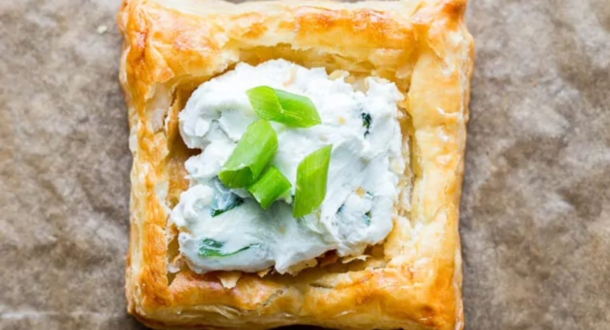 Overhead image of creamy blue cheese puff pastry square with garnish.