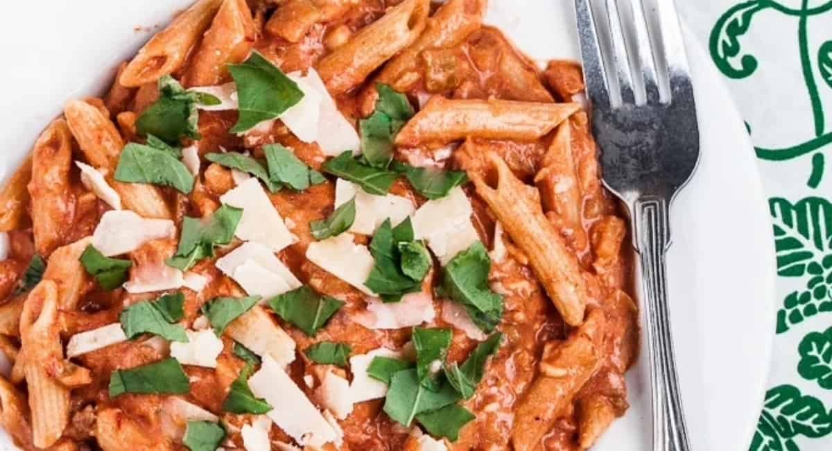Overhead image of creamy bruschetta pasta with garnish.