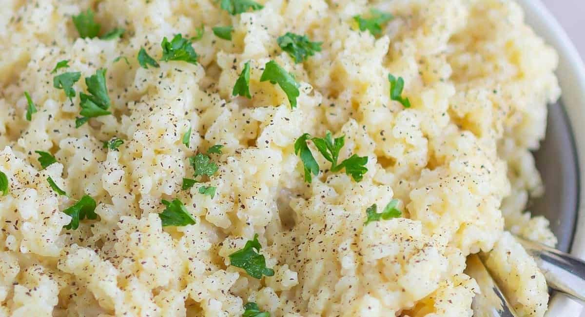 Overhead close up of creamy Parmesan rice with garnish.