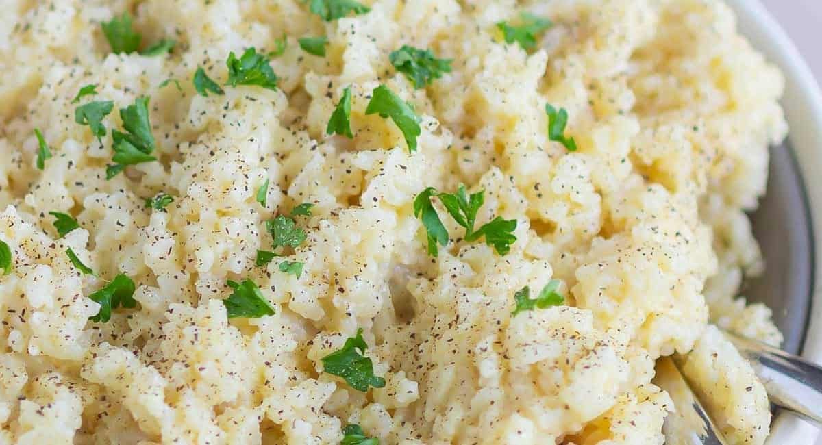 Up close overhead image of creamy parmesan rice with garnish.