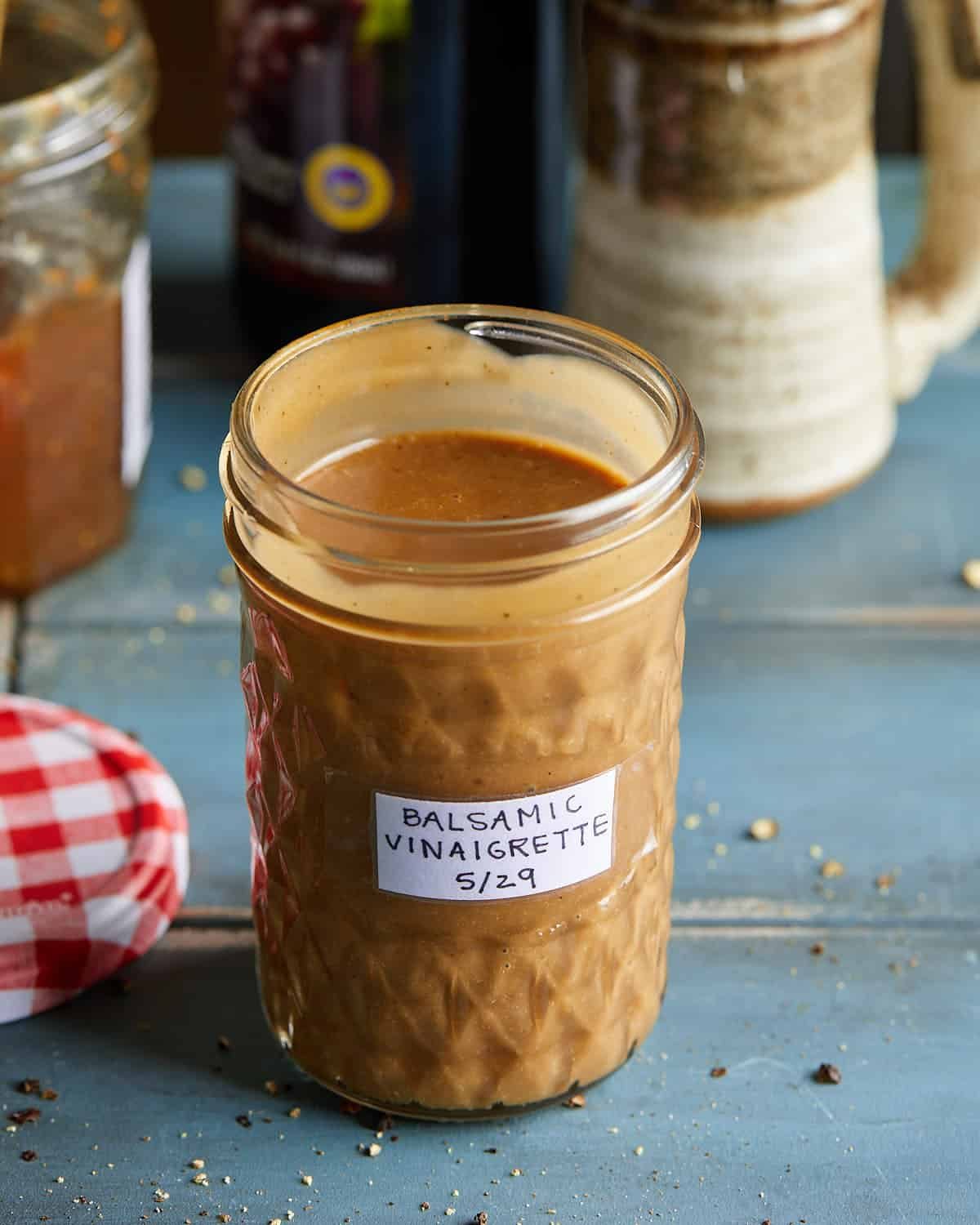 Up close image of mason jar with creamy balsamic vinaigrette with label that says 'balsamic vinaigrette 5/29'.