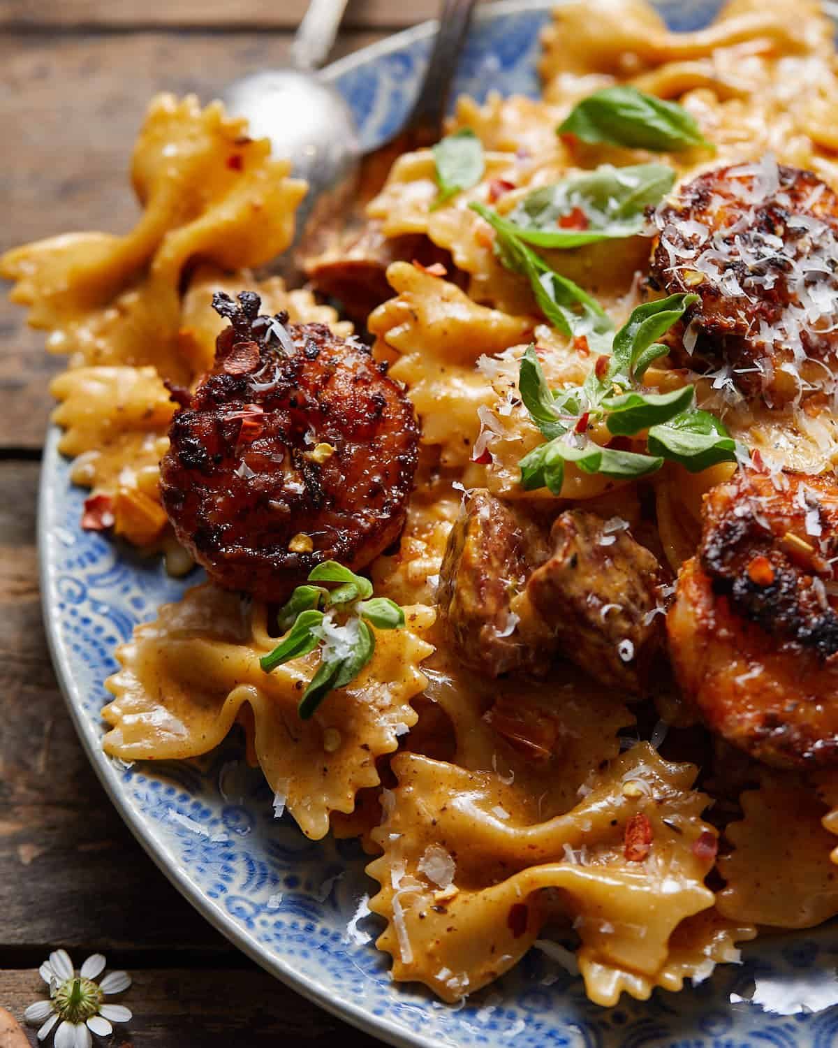 Up close image of creamy cajun shrimp and sausage pasta with garnish.