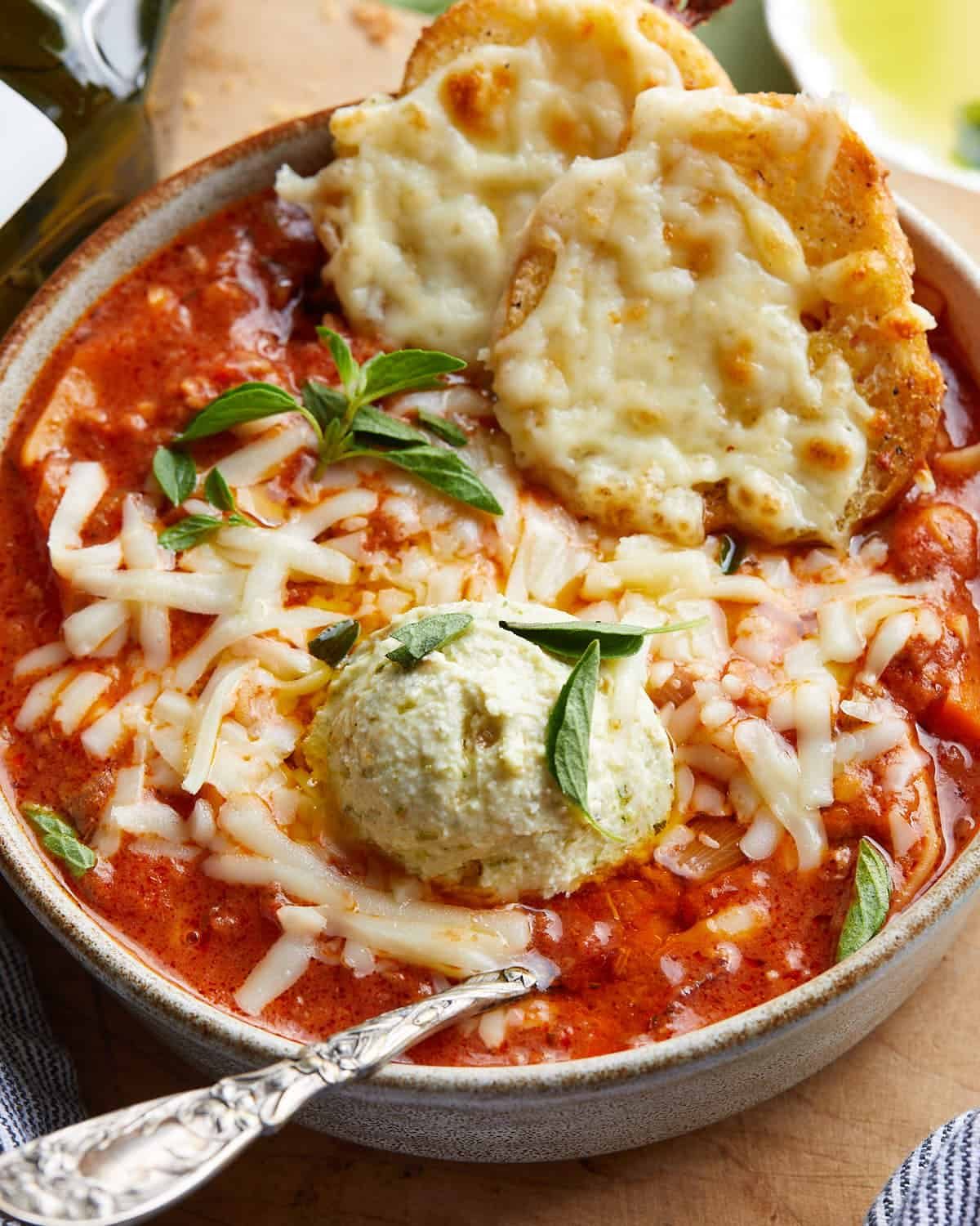 Up close image of creamy lasagna soup with garnish.