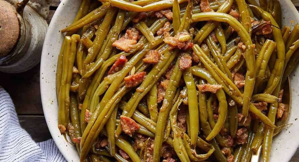 Overhead image of crockpot green beans in white dish.