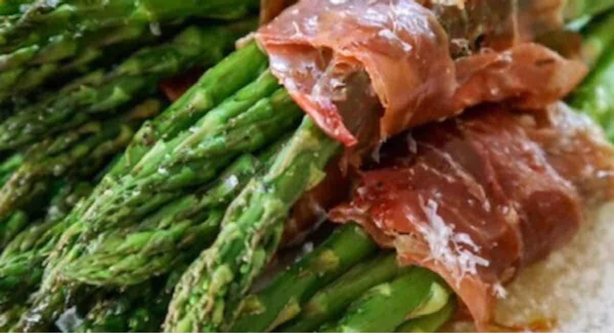 Up close image of wrapped asparagus with proscuitto and cheese.