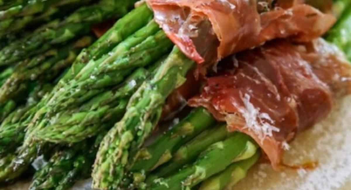 Up close image of prosciutto wrapped asparagus with cheese.