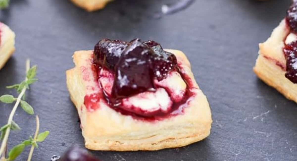 Overhead up close image of puff pastry appetizer with goat cheese and cherry compote.