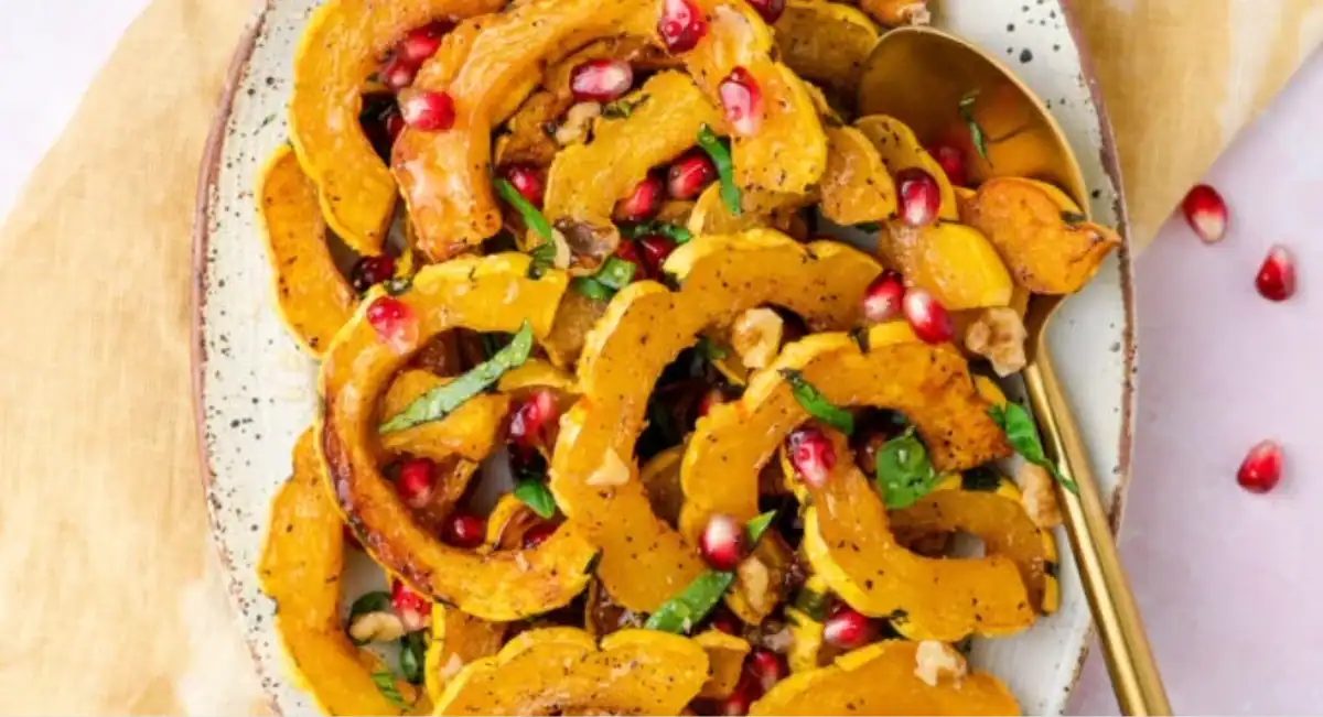 Overhead image of honey-roasted delicata squash with garnish on white dish.