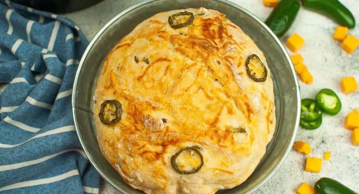 Overhead image of dutch oven jalapeno cheddar bread in silver tin dish.