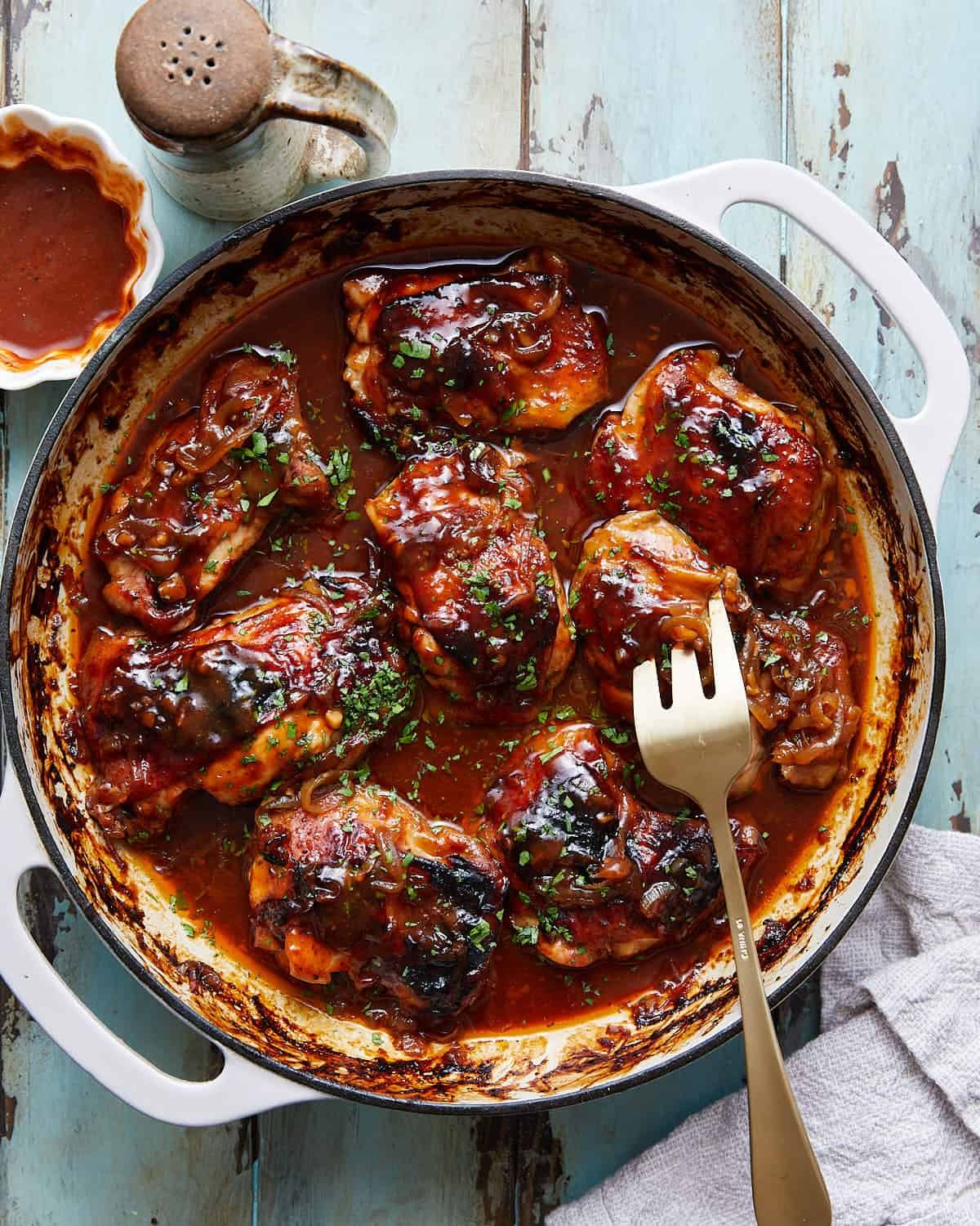 An overhead image of dutch oven bbq chicken and garnish.
