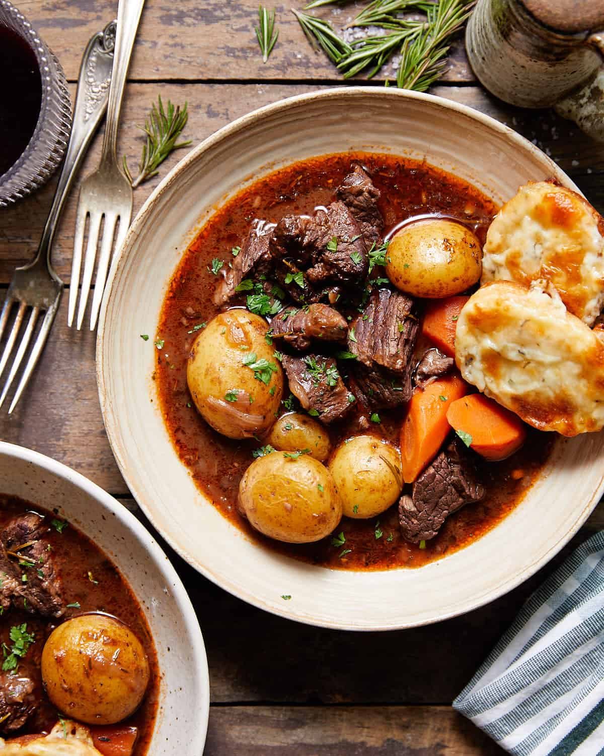 Overhead image of dutch oven beef stew in bowl with garnish.
