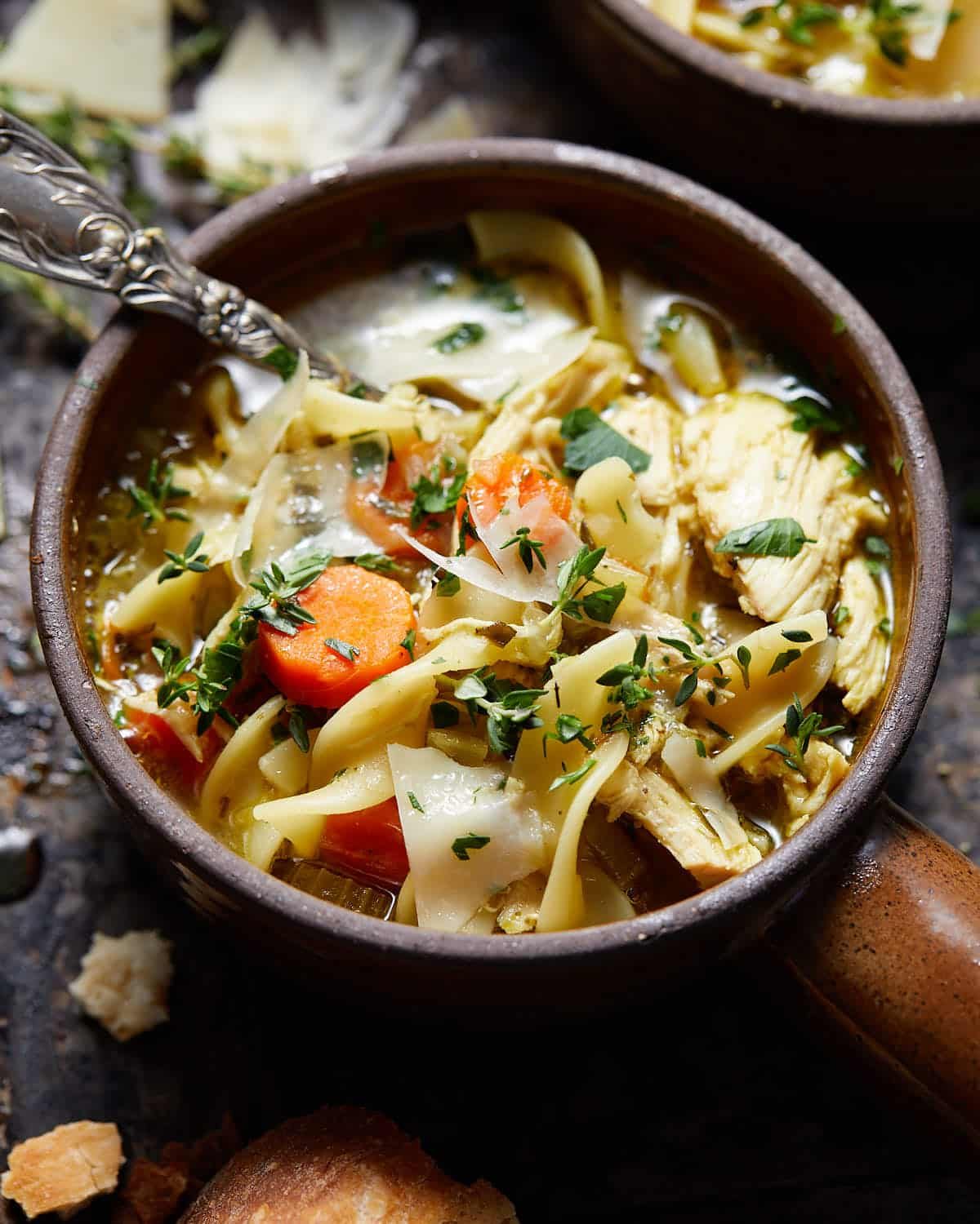 Dutch oven chicken noodle soup with parmesan cheese on top.