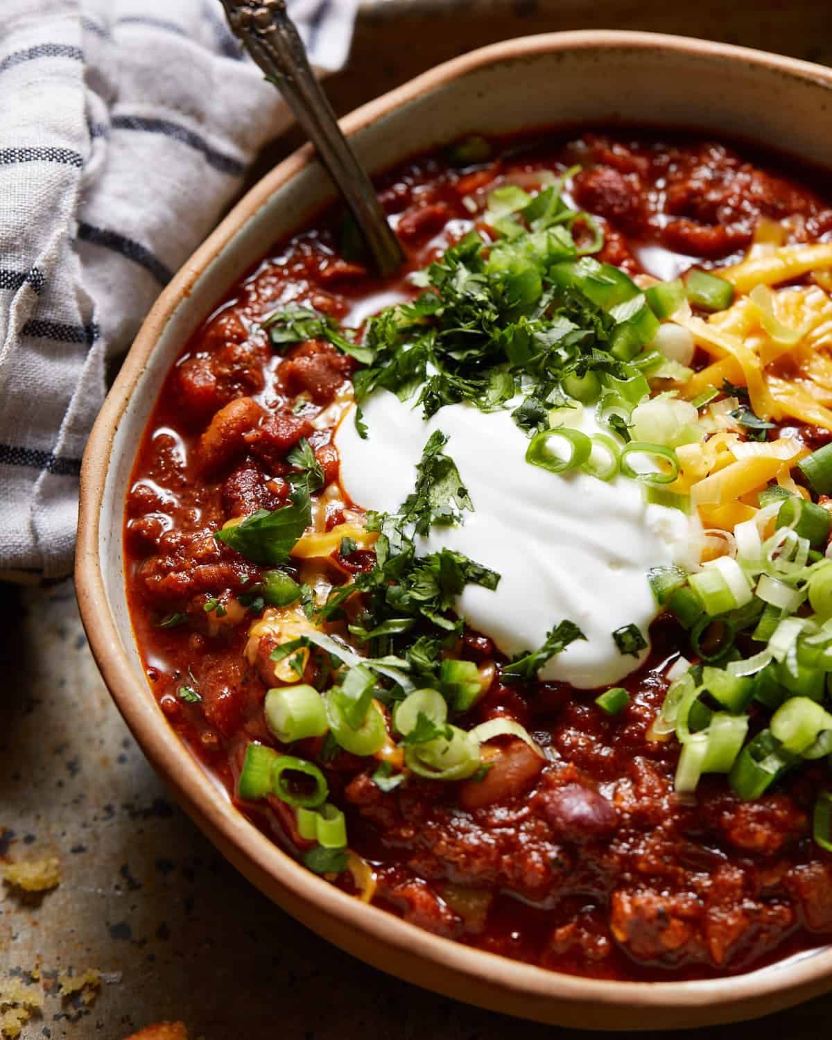 Dutch oven chili in a bowl with toppings.
