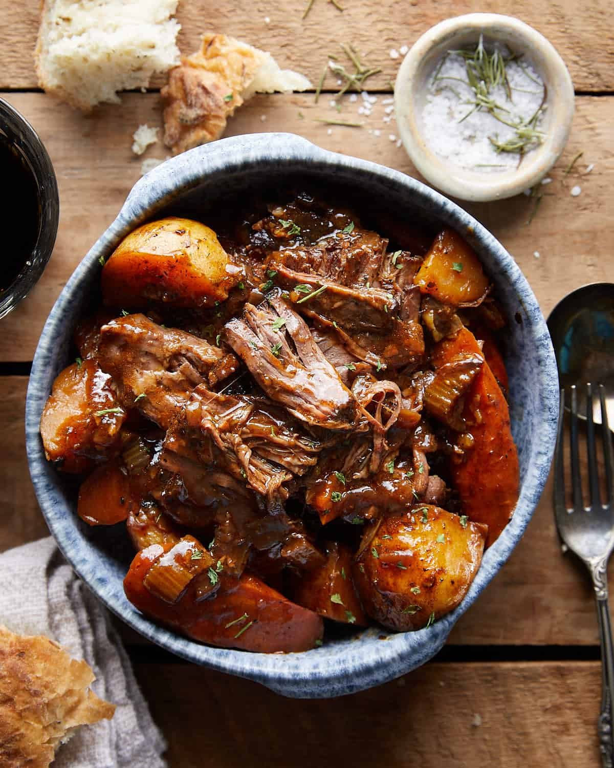Overhead view of shredded Dutch Oven Pot Roast in a blue bowl.