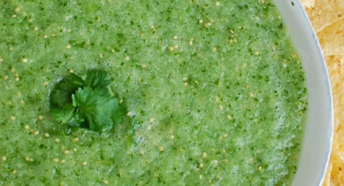 Overhead up close image of tomatillo salsa verde with garnish.
