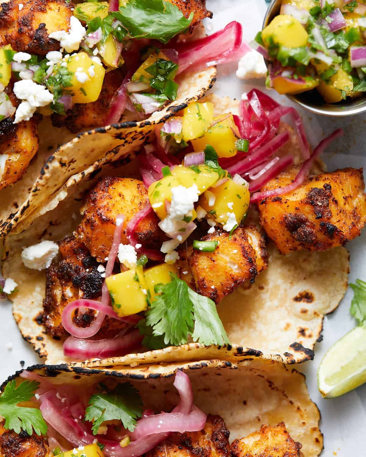 An up close image of a fish taco with mango salsa.