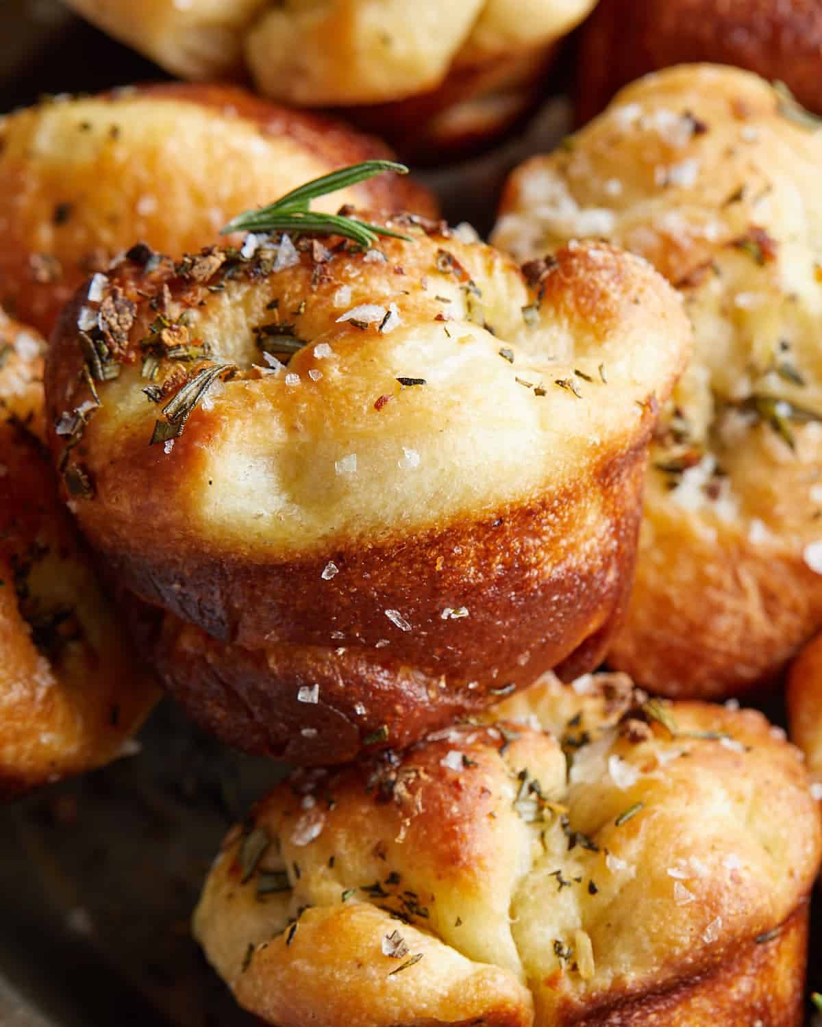 Up close image of focaccia muffins with garnish.