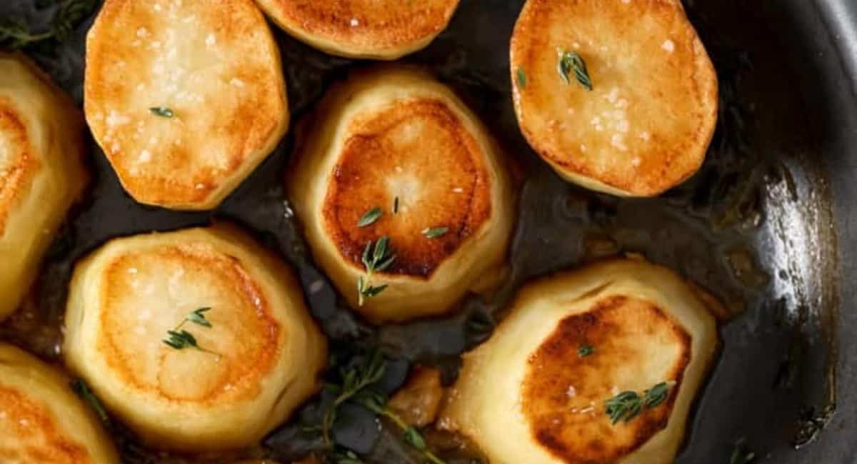 Overhead image of fondant potatoes with garnish.