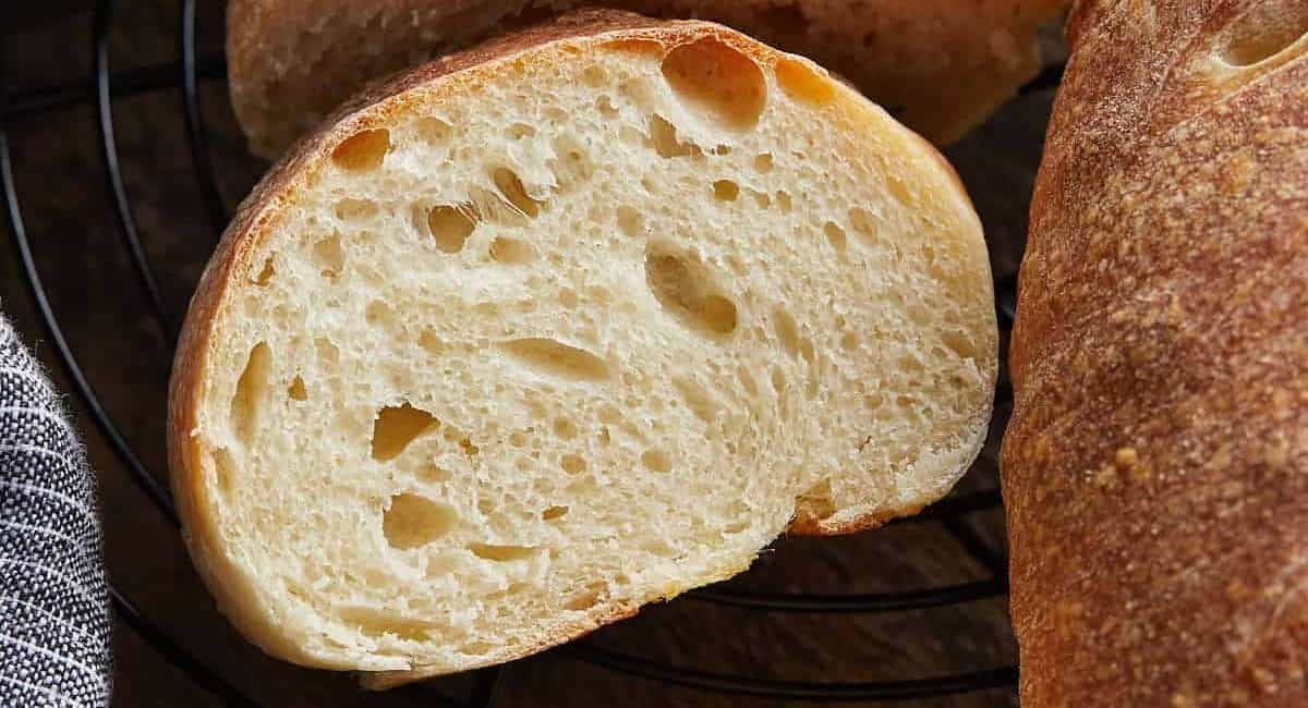 Overhead image of homemade french bread recipe on black wire rack.