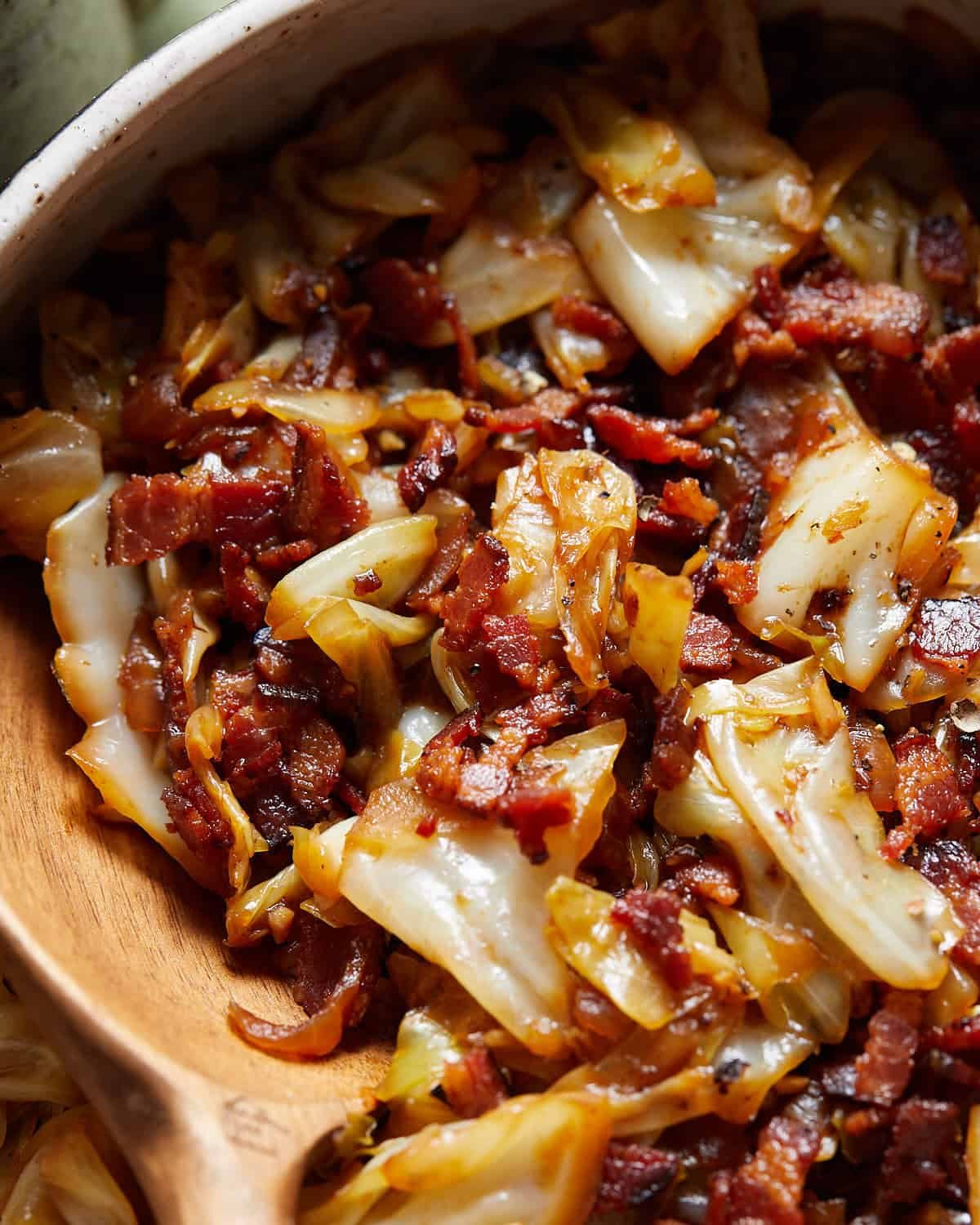 Up close image of fried cabbage with bacon & onion.