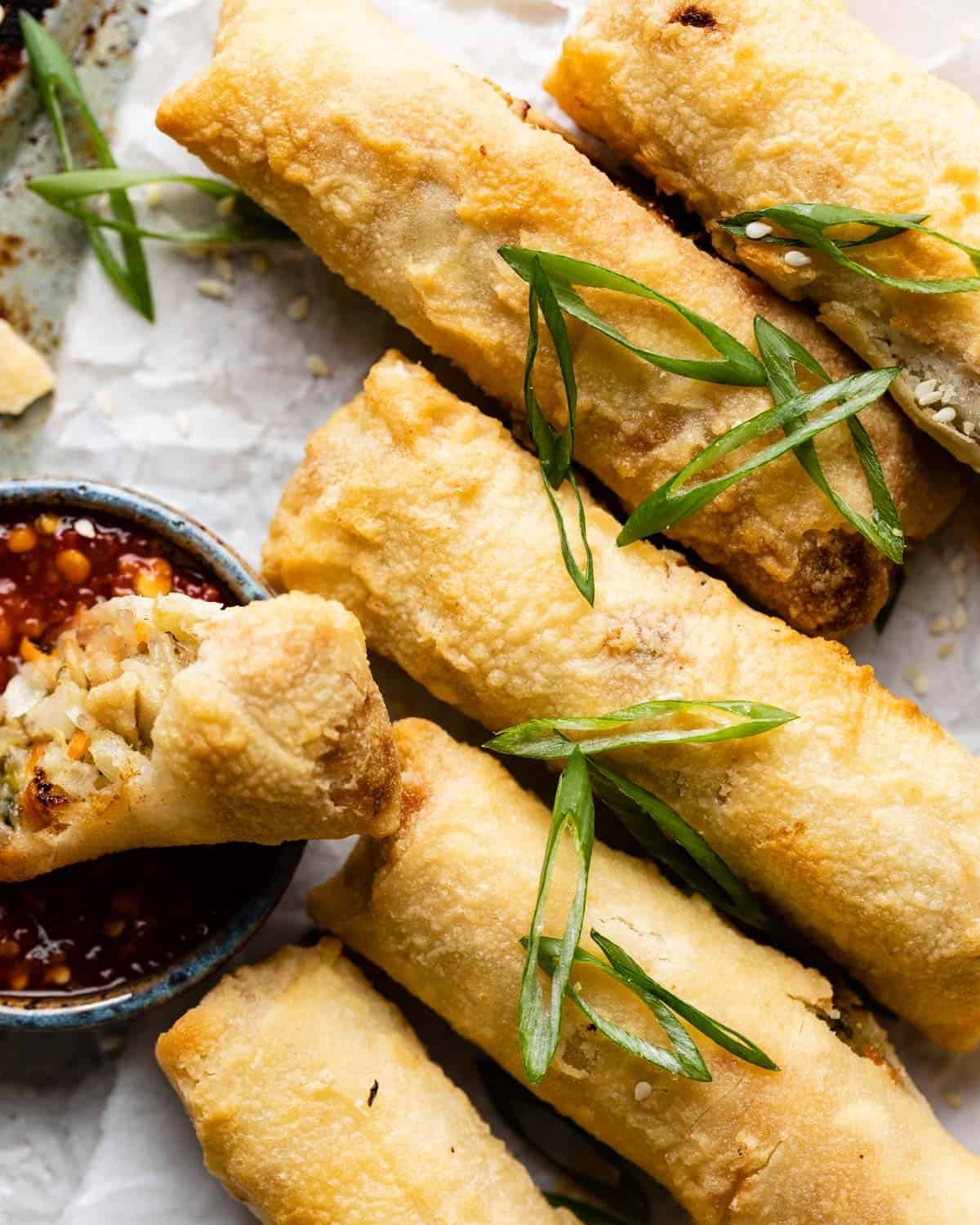 Up close image of air fryer egg rolls with garnish.