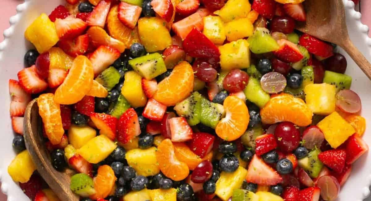 Overhead image of rainbow fruit salad with honey lime dressing.
