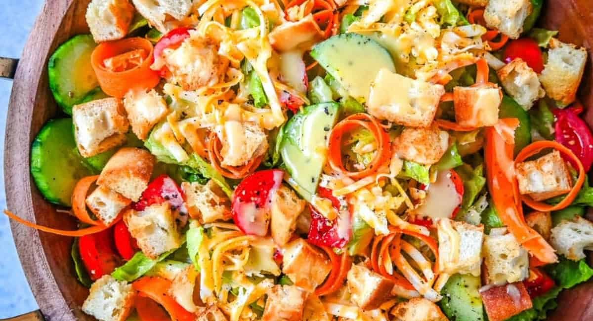 Overhead image of garden salad recipe in wooden bowl.