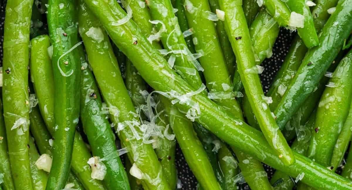 Up close image of garlic parmesan green beans with garnish.