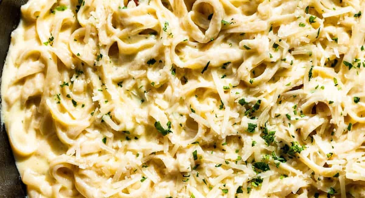Overhead image of garlic parmesan pasta with garnish.