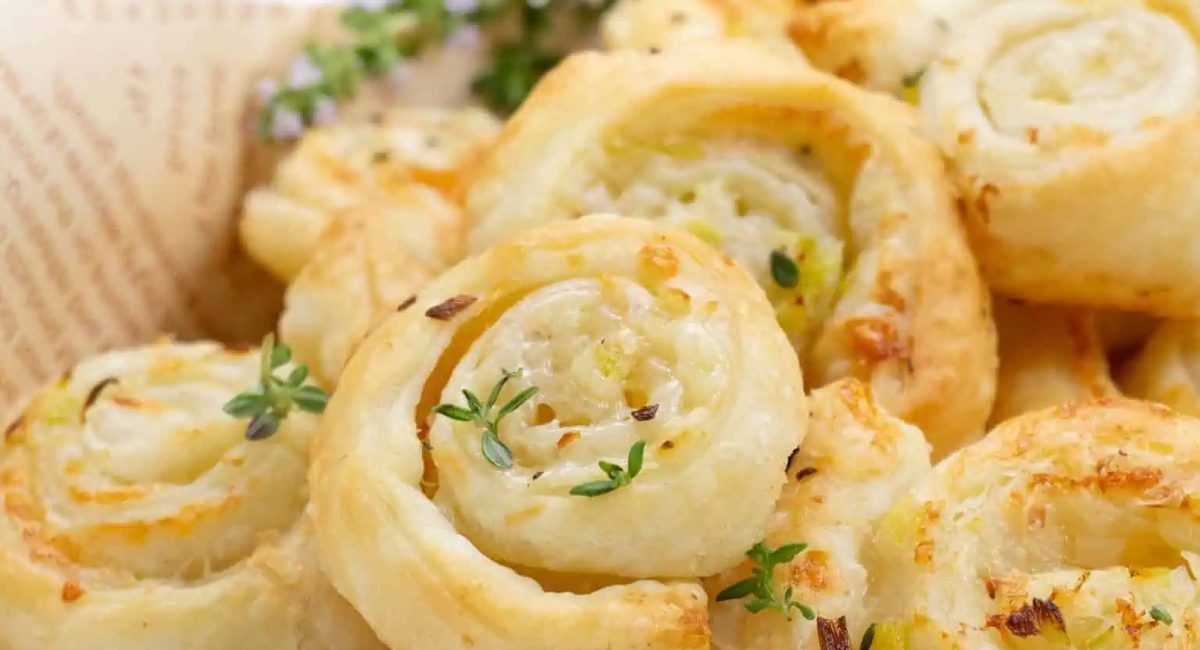 Up close image of tender garlic puff pastry pinwheels with garnish.