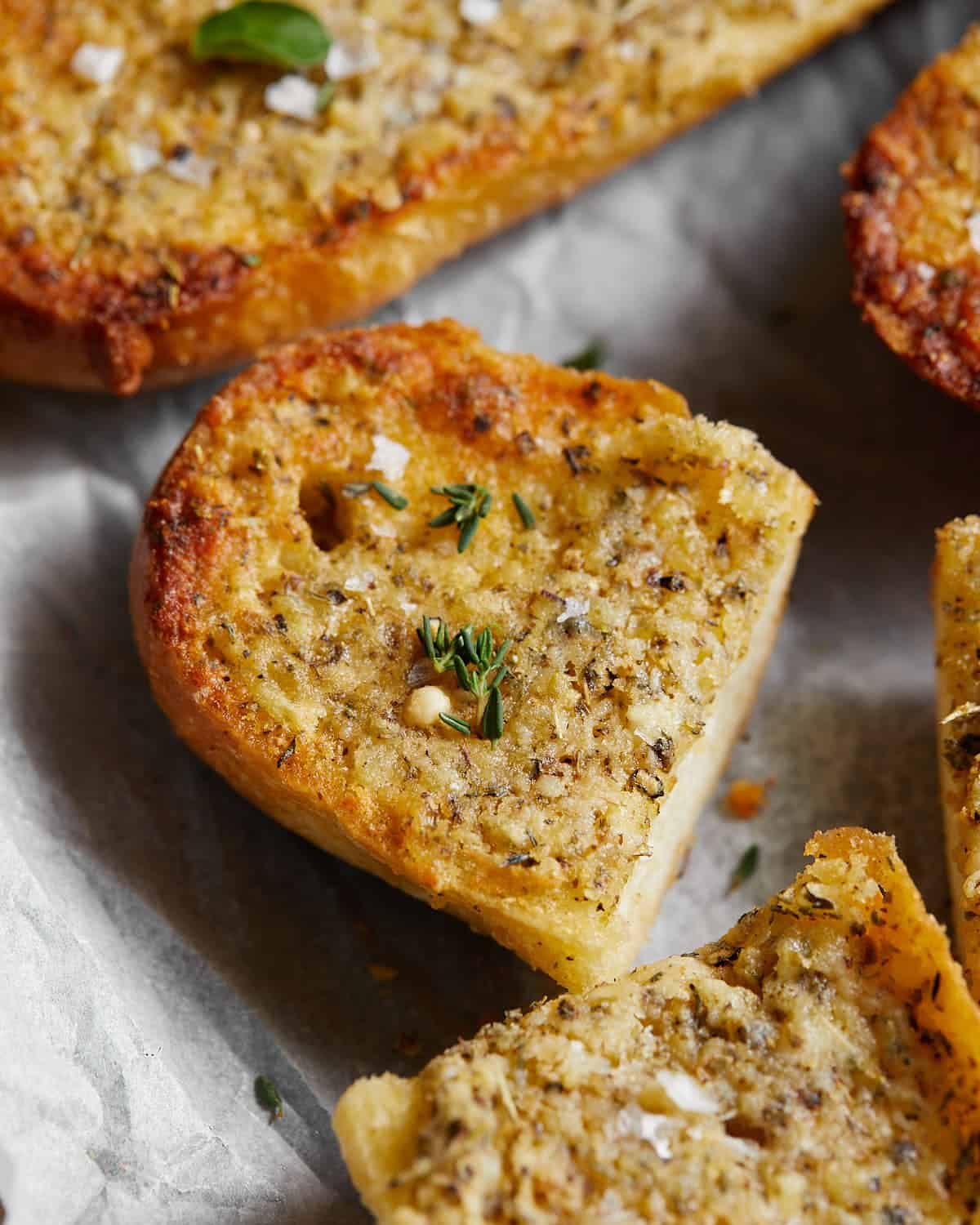 Up close image of garlic bread spread with garnish.