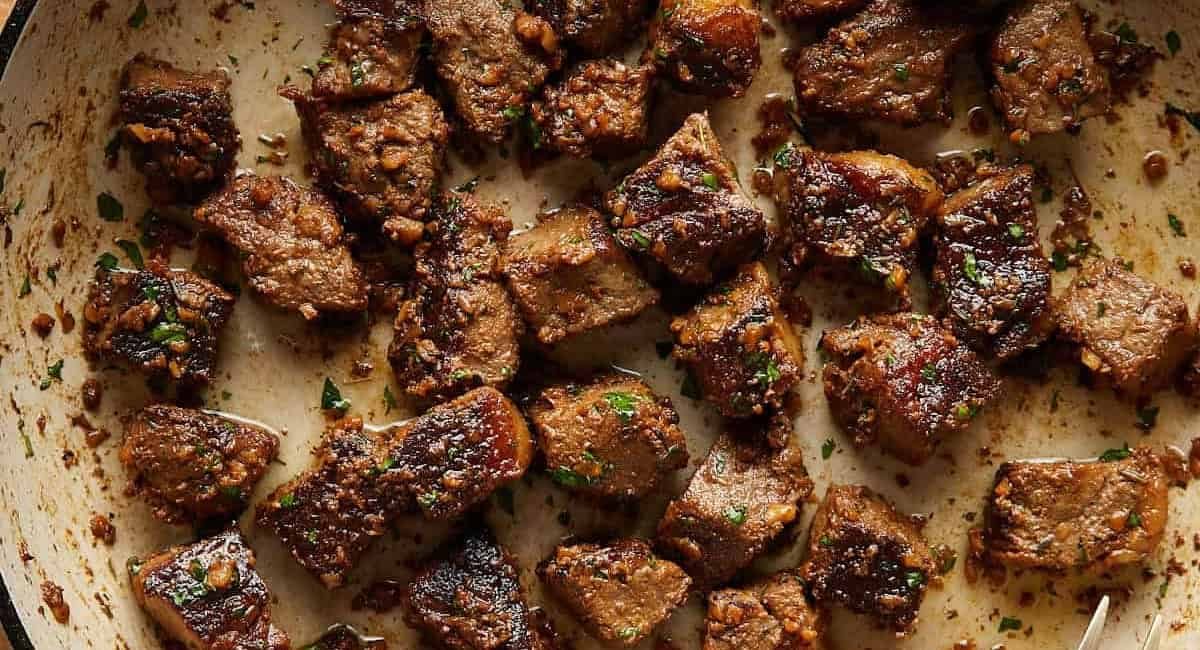 Overhead image of garlic butter steak bites with garnish.