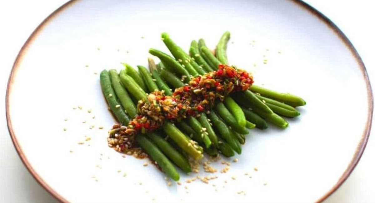 Overhead image of green beans with asian sauce.