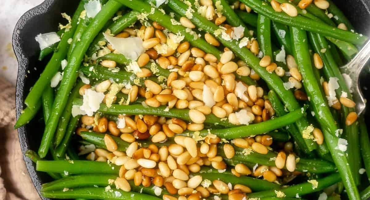 Overhead image of green beans with parmesan and pine nuts.