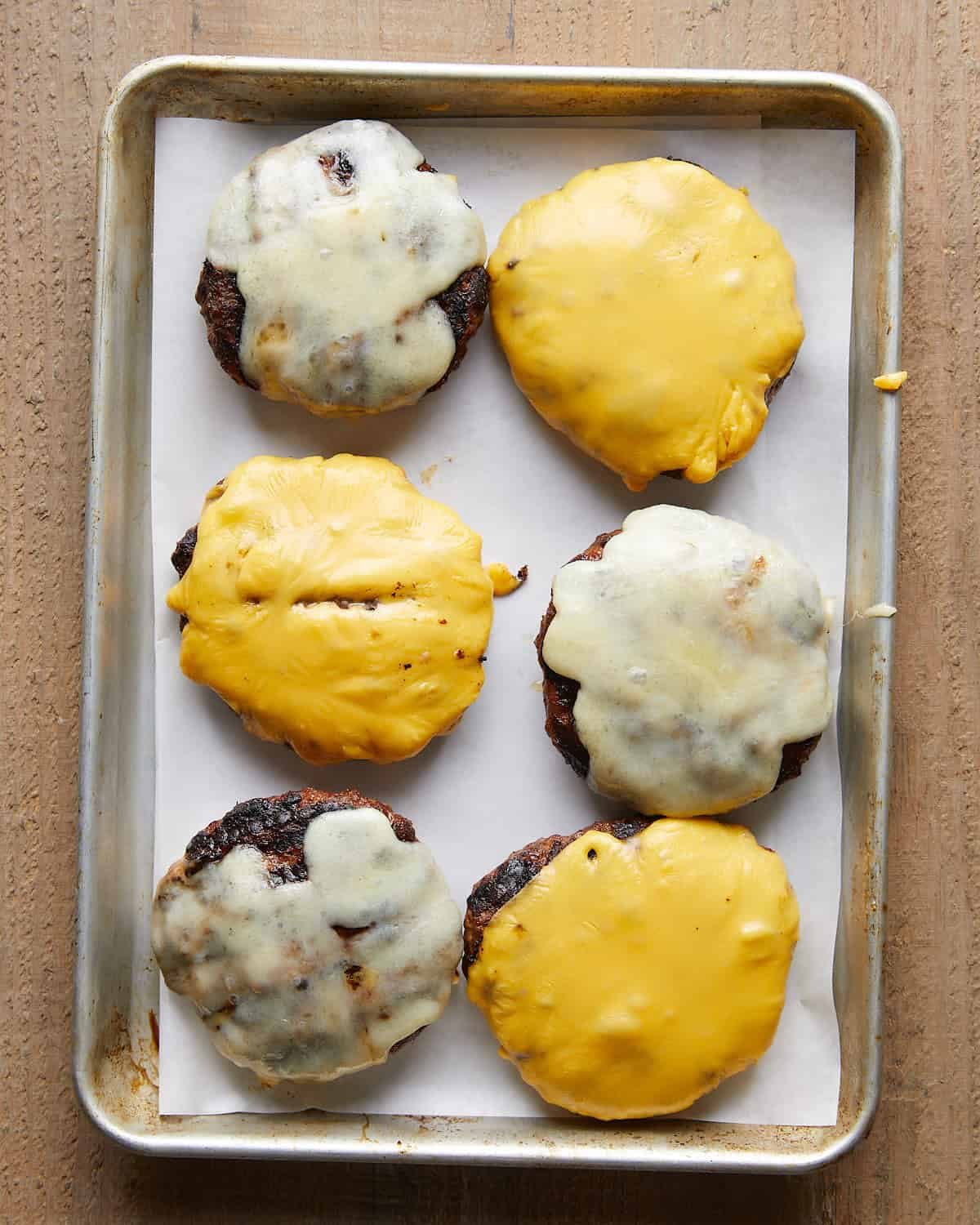 Grilled burger patties topped with melted cheese.