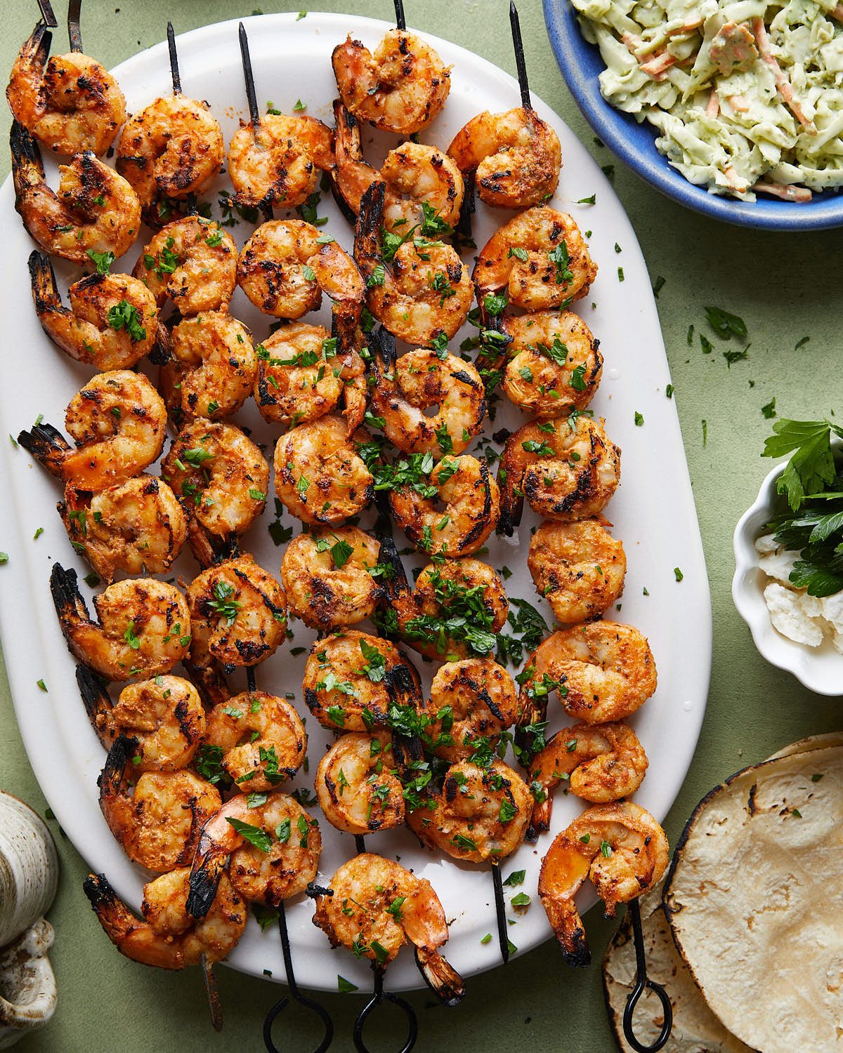 Overhead image of grilled shrimp skewers with garnish.
