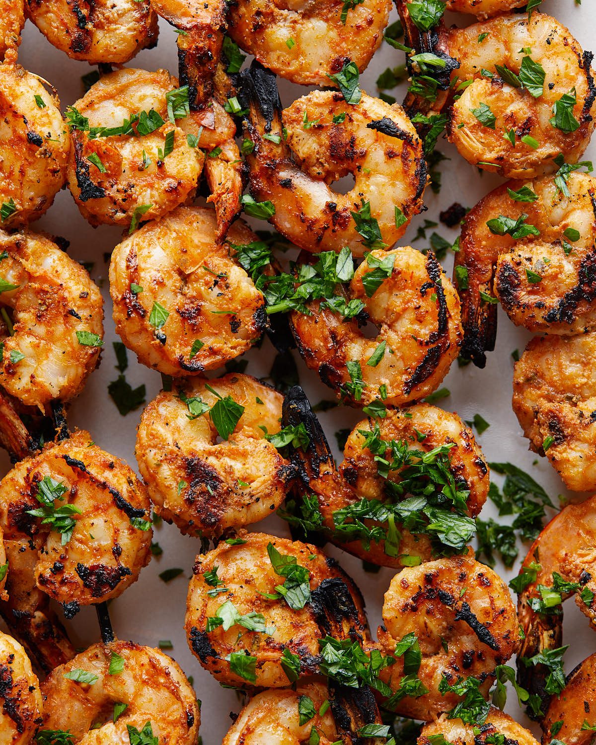Up close overhead image of grilled shrimp skewers with garnish.