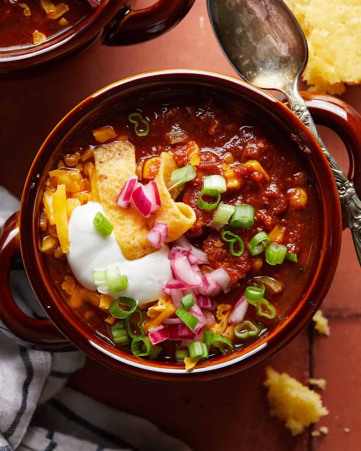 Up close overhead image of ground chicken chili in bowl with toppings.