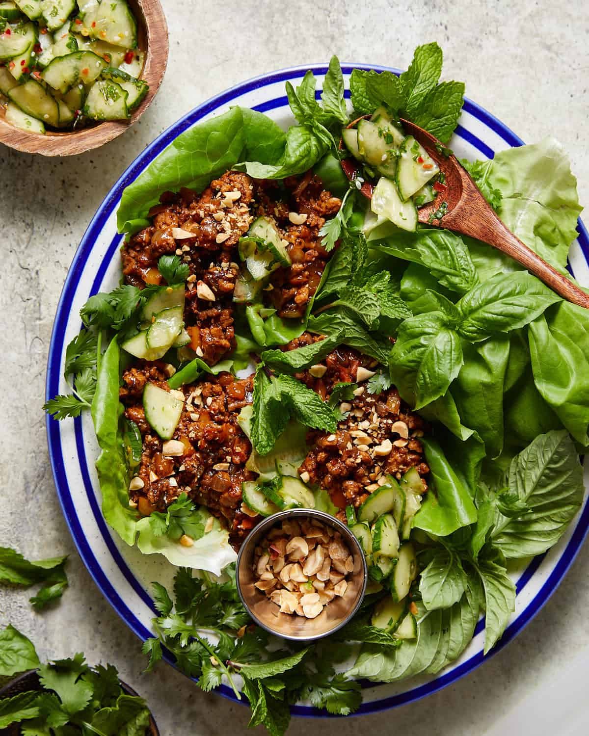 Ground chicken lettuce wraps on plate with fresh herbs.